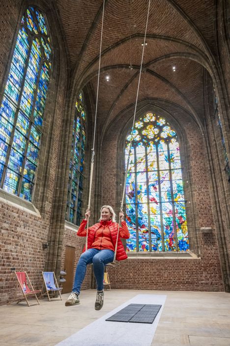 Besucherin auf einer Schaukel im Innenraum der Unser Lieben Frauen Kirche