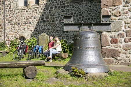 Radfahrendes Paar macht Pause vor dem Kloster Zeven