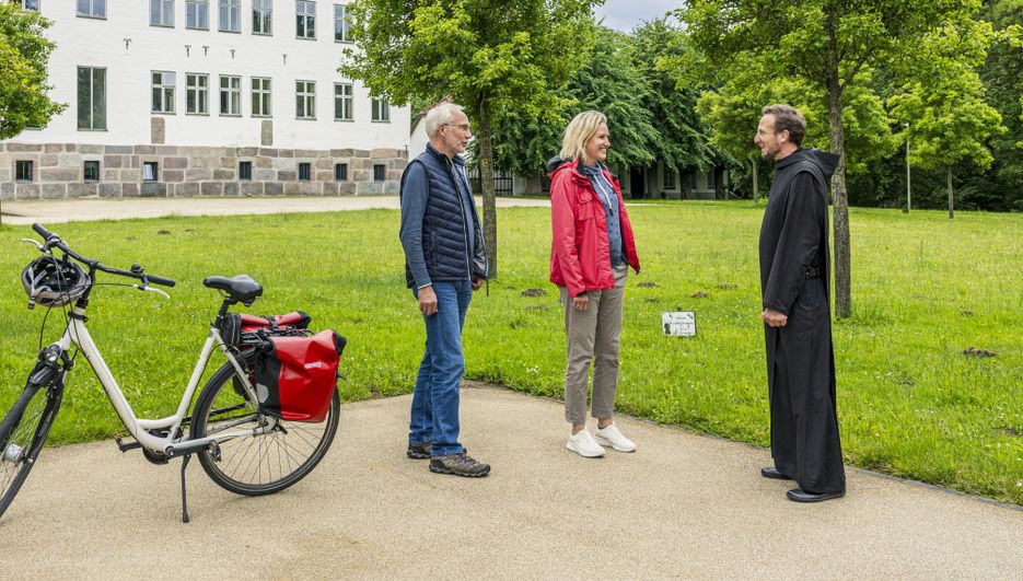 Radreisende sprechen mit einem Mönch 
