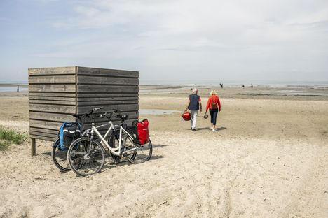 Radreisende spazieren am Grüner Brink Strand