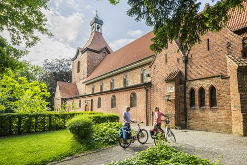 Radreisende pausieren an der St.-Johannis-Kirche in Oldenburg in Holstein