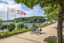 Radreisende fahren entlang des Dieksees in Malente