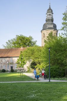 Radfahrende schieben Rad Richtung Zevener Kloster