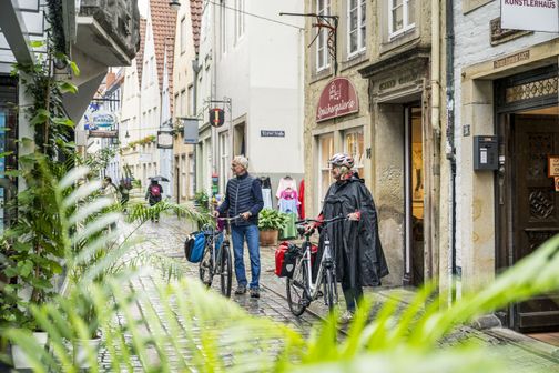 Paar mit Rad unterwegs in Bremen Schnoor