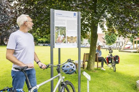 Radreisender betrachtet eine Infotafel auf dem Kirchplatz der Marienkirche
