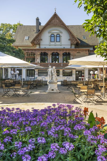 Aufnahme von Blumen im Vordergrund und einer Statue im Hintergrund im Bürgerpark Bremen