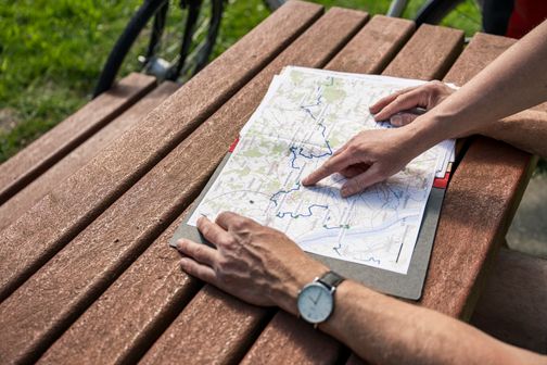 Radreisende studieren eine Karte am Deich in Borsfleth