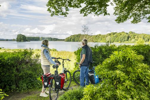 Radreisende blicken von dem Friedhof der St.-Petri-Kirche auf den Bischofssee
